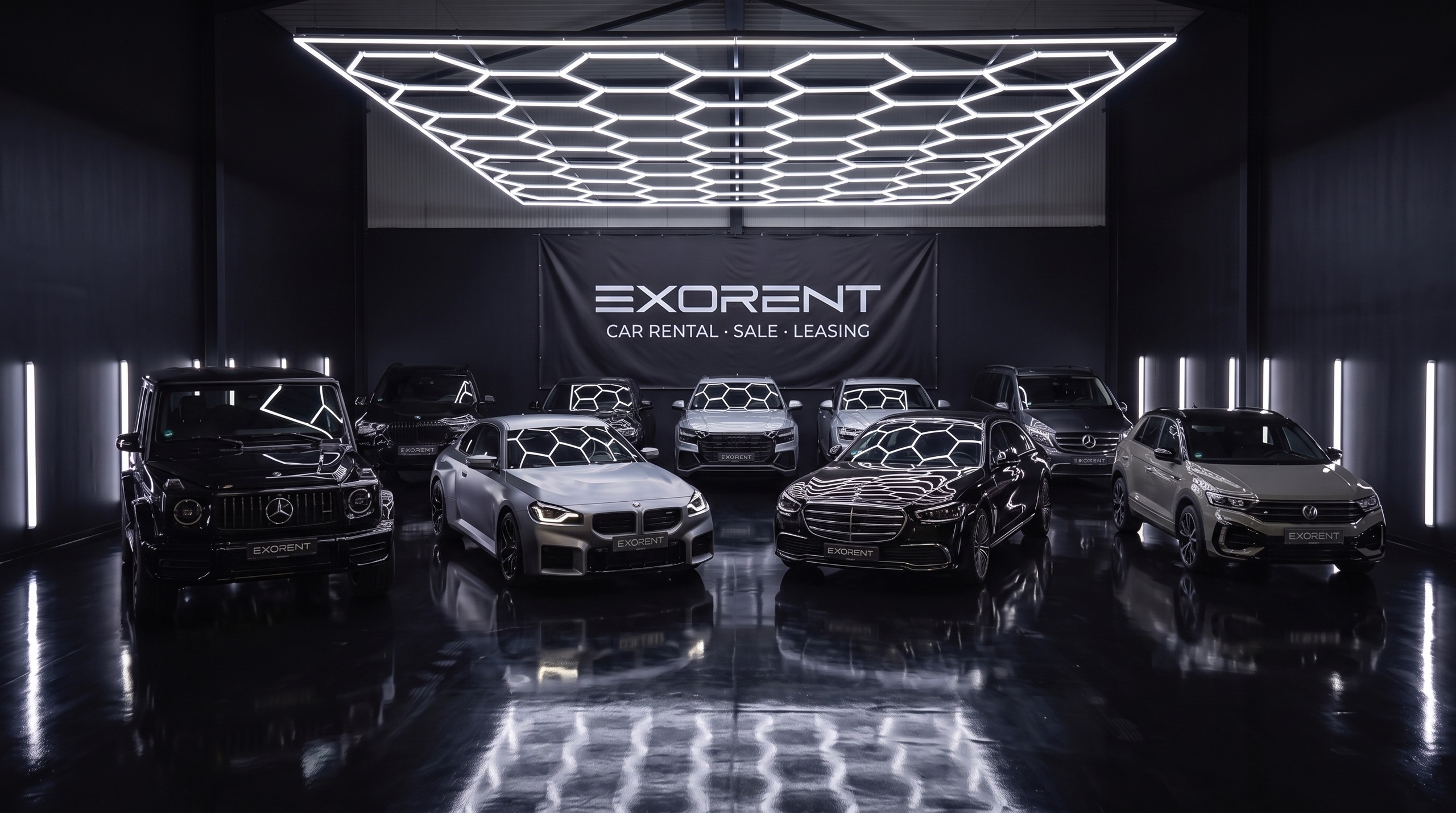 Der gesamte EXORENT Fuhrpark in der Halle: G63, BMW M2, X7, Audi Q8, Mercedes S-Klasse, V300 und VW T-Roc R