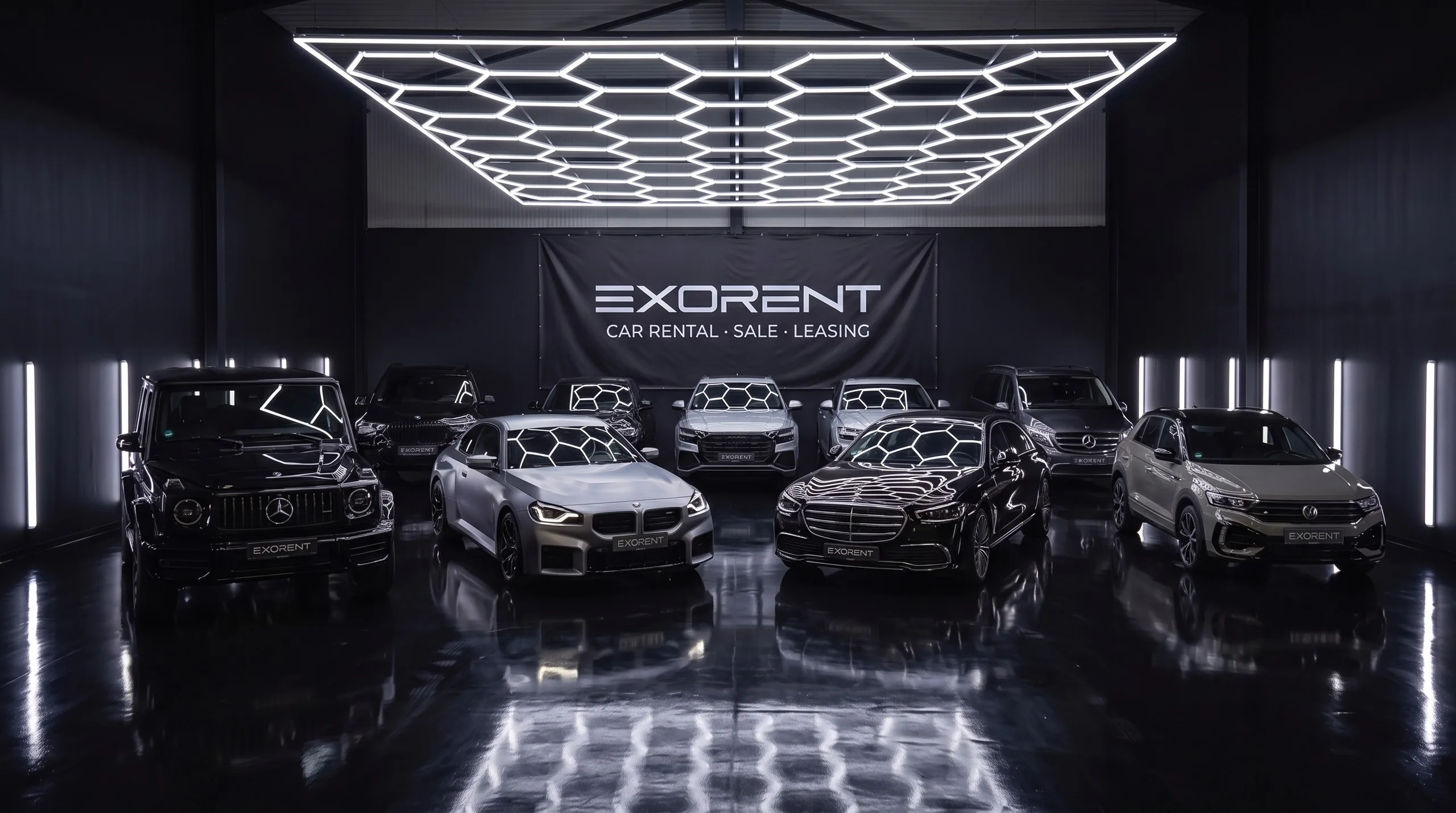Der gesamte EXORENT Fuhrpark in der Halle: G63, BMW M2, X7, Audi Q8, Mercedes S-Klasse, V300 und VW T-Roc R